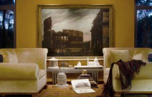 Room All Roads Lead to Roman Ruins- Guest Blog by Piraneseum Fig. 1 Gian Paolo Panini, Capriccio of Roman Ruins, c.1760. A characteristic painting by this master of imaginary and realistic views of the city’s ancient landmarks. This scene incorporates a range of ruined landmarks – Colosseum, Pyramid of Caius Cestius, Arch of Janus, Arch of Constantine, Trajan’s Column, and Temples of Vesta, Saturn and of Castor and Pollux, etc. – into a wholly imaginary, highly picturesque landscape.